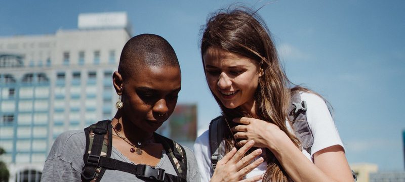 Two travelers checking a phone in the city