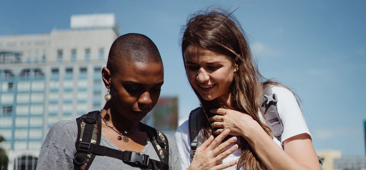 Two travelers checking a phone in the city
