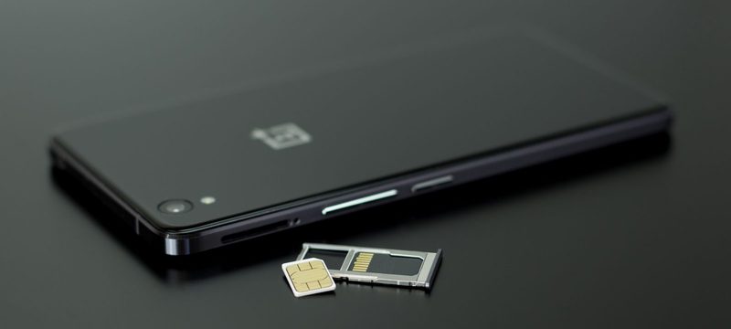 Black phone with a SIM card and its tray