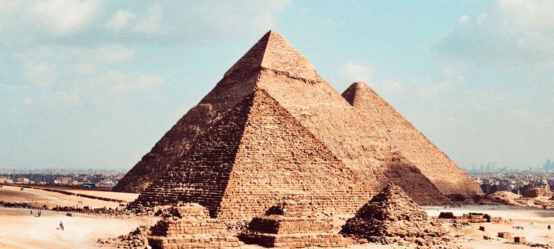 Les pyramides de Gizeh sous un ciel bleu nuageux, en Égypte