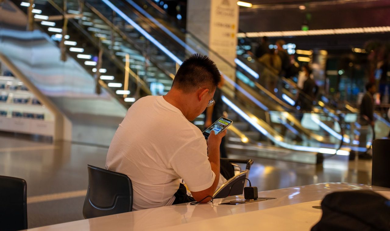 Traveler checking his phone in an airport terminal